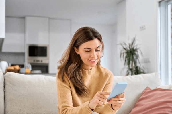 Windstream Internet Service for Modern Needs A woman on a couch, engaged with her phone, appearing relaxed and comfortable