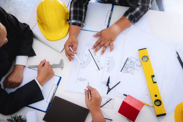 Building Trust and Quality: Your Go-To Team for Construction in Denton engineer people meeting working and pointing at a drawings in office for discussing. Engineering tools and construction concept.